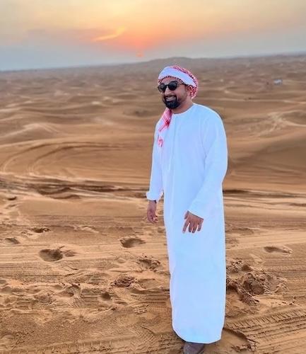 Matt Sheikh dress in traditional attire in the desert.