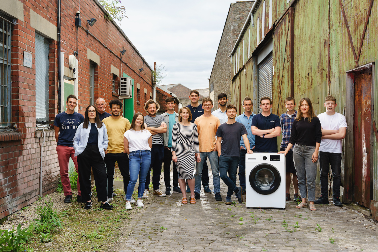The Matter team stands next to a washing machine. 