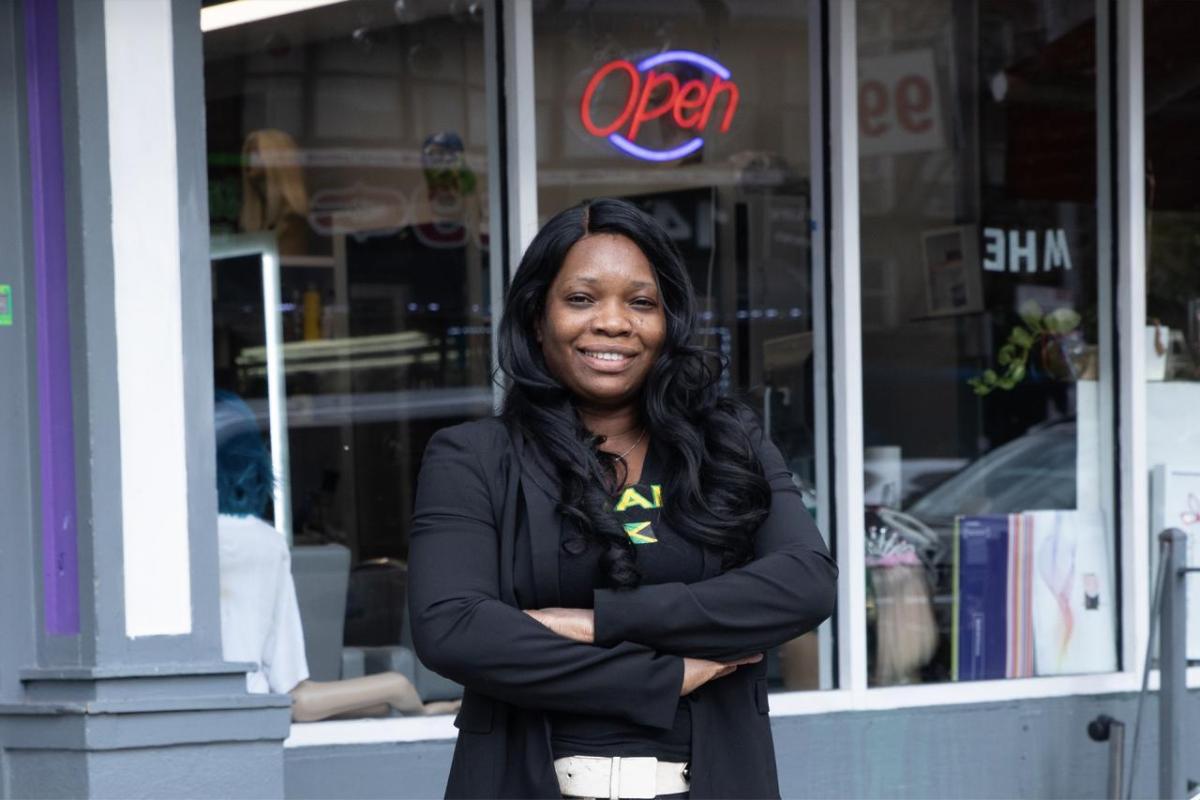 Mitzie outside of a store with a lit "Open" sign.