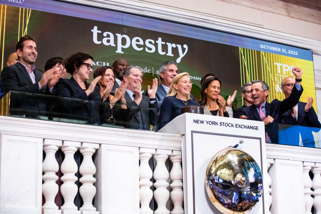 Joanne Crevoiserat ringing the opening bell at the NYSE. A team of people behind her.