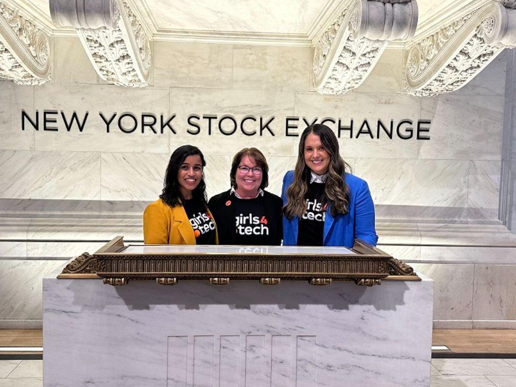 Three people posed at a podium. "NEW YORK STOCK EXCHANGE' behind them.