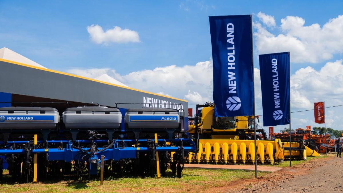 Large New Holland banners next to pieces of agricultural equipment