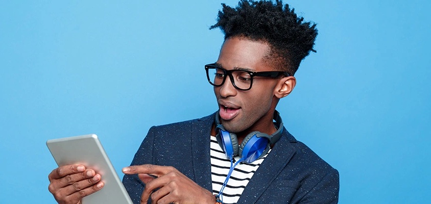 young black male with tablet and headphones