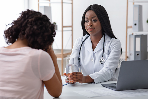 Black Female Doctor consulting with a patient.