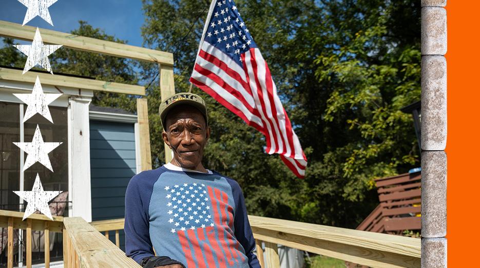 Operation Surprise: A Veteran shown in front of his home with an American flag waving in the background.