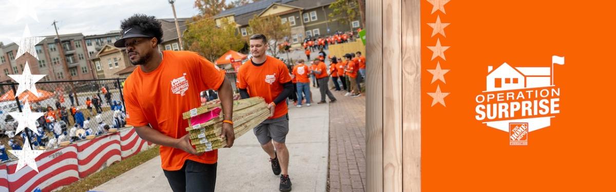 Operation Surprise! The Home Depot volunteers shown carrying lumber.