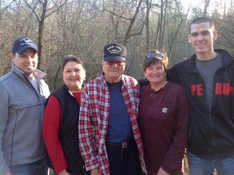 Donna Janssen and family standing in front of forest