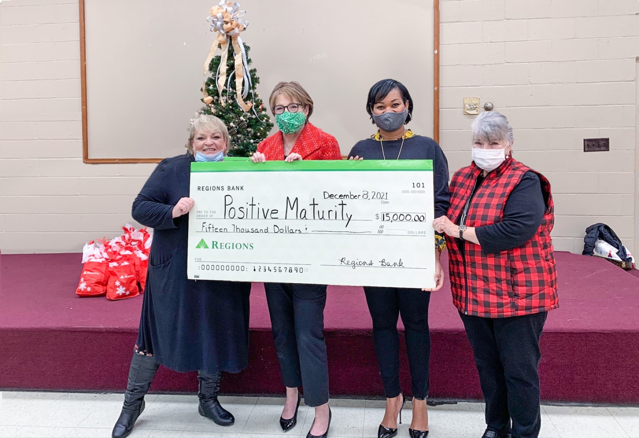 4 women holding large check