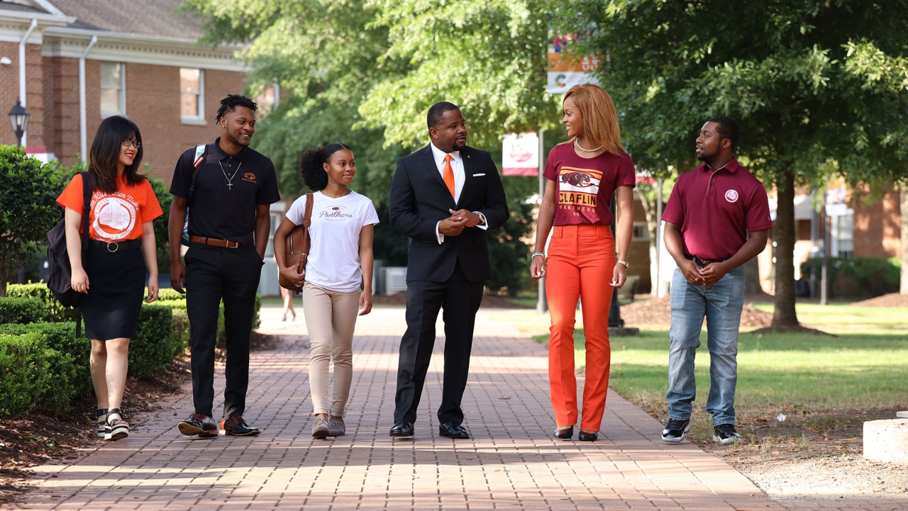 President Warmack walking with students. 