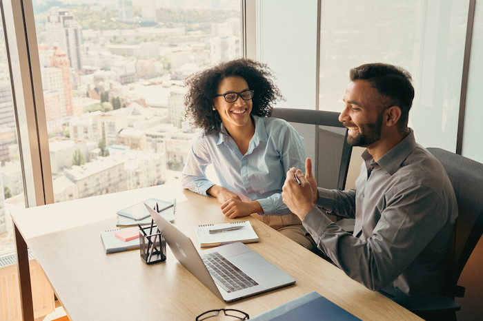 two people at a desk with a computer