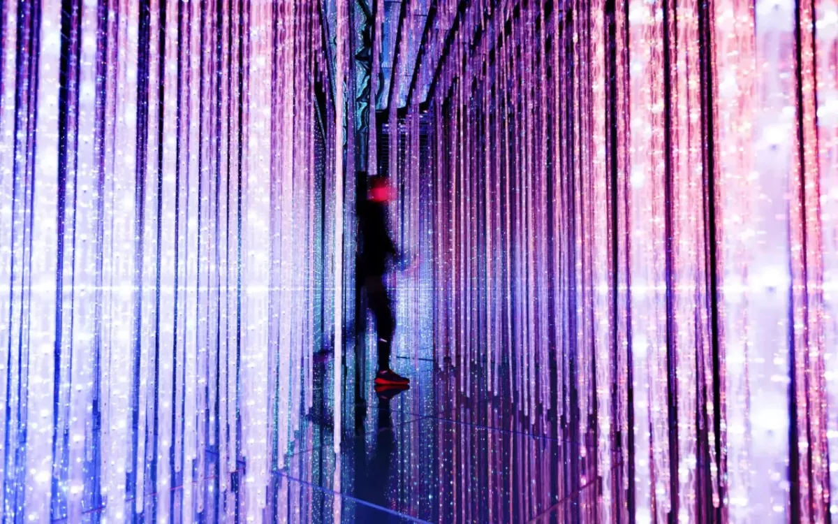 Figure walking through room with vertical purple lights