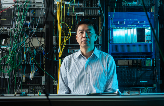 Dr. Tao Luo in front of a giant mainframe