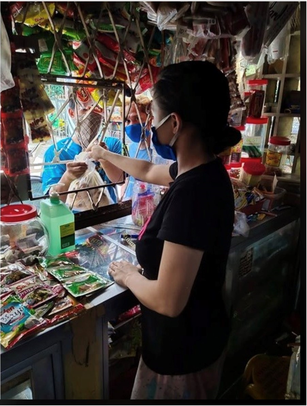 Image of a woman wearing a mask and handing out food