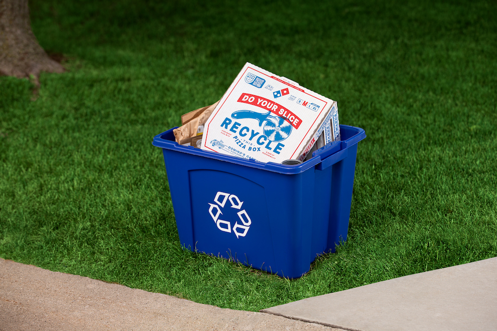 A pizza box inside a recycling container 