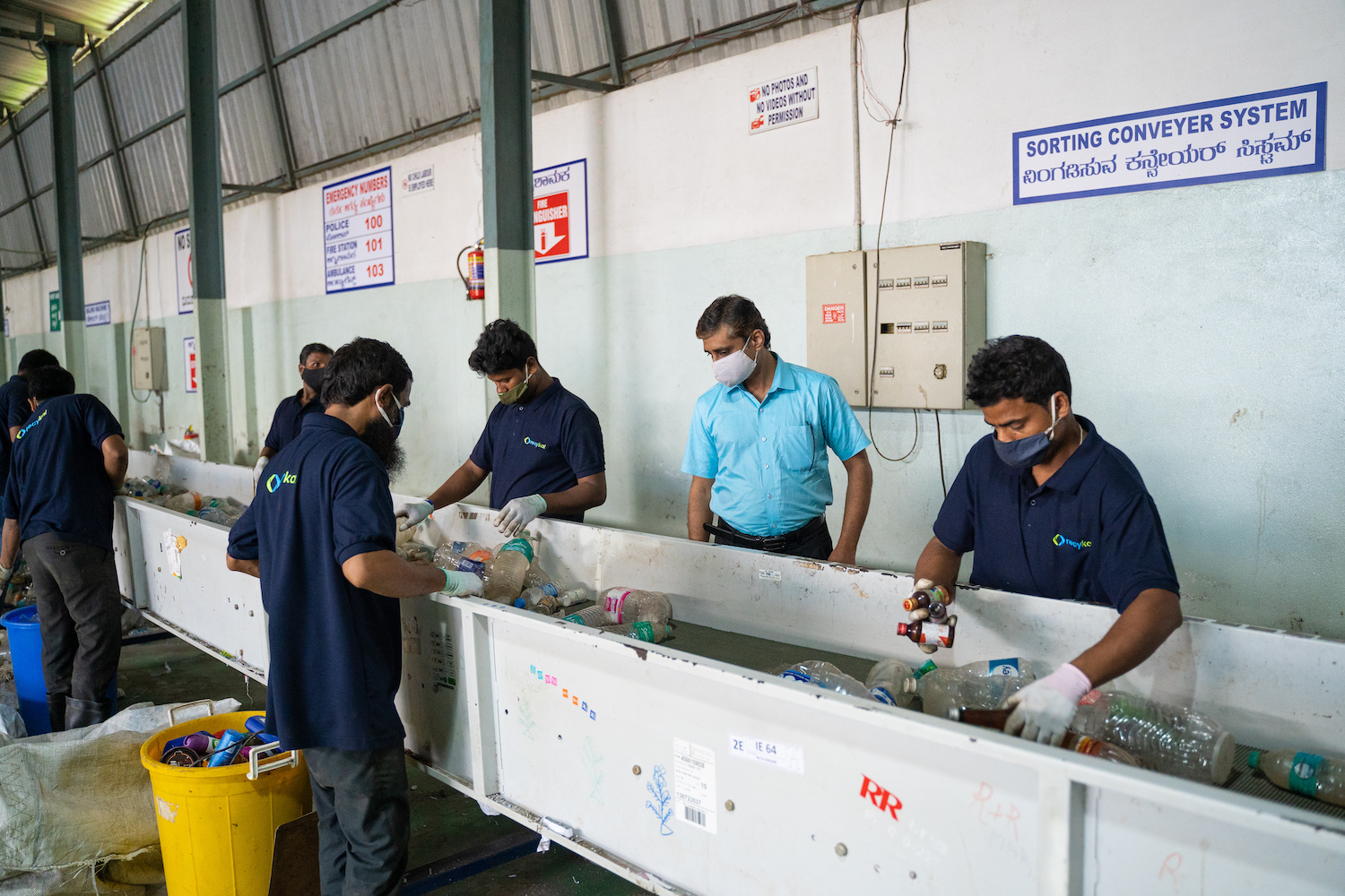 Members of the Recykal team separate recyclable materials at a recycling center that processes ocean-bound plastic pollution and other materials in Bengaluru, India.