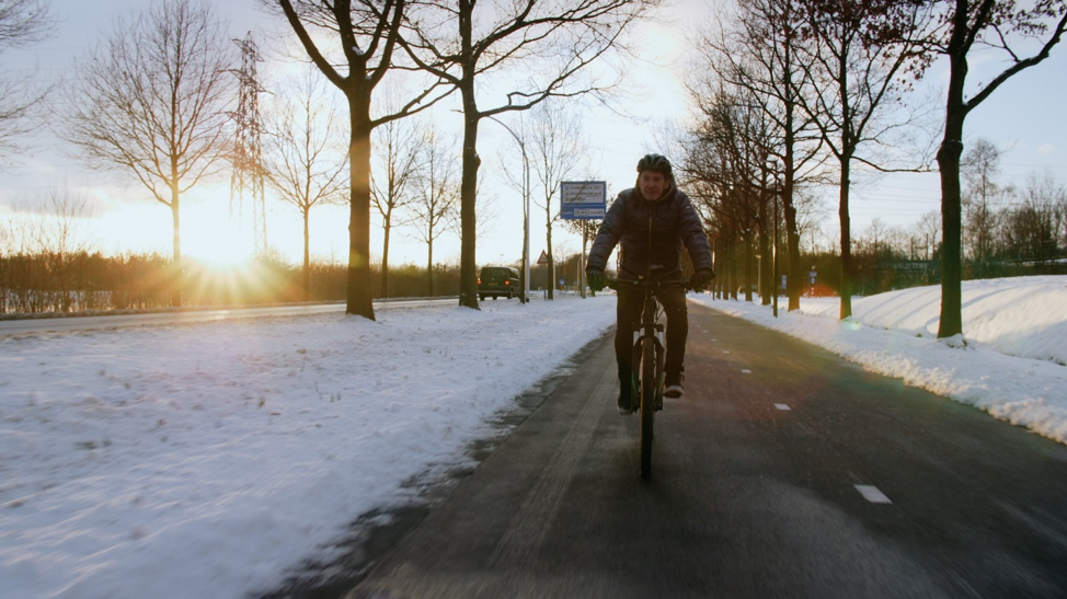 person riding a bike on a bike path in winter