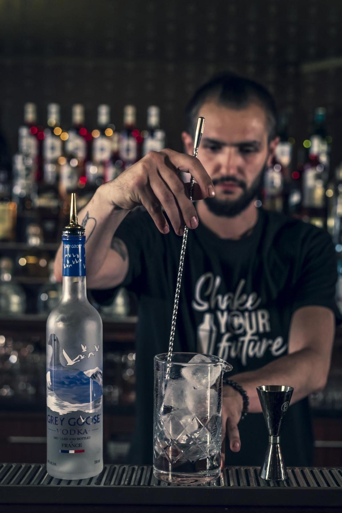 A bartender training  student mixing a drink