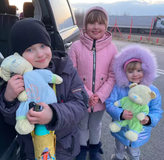 Children snuggle new toys during the journey
