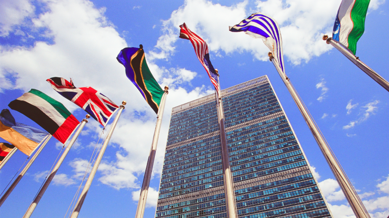 upward view of flags in front of the UN building