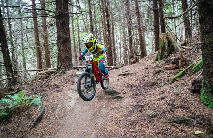 a child dirt biking in the woods