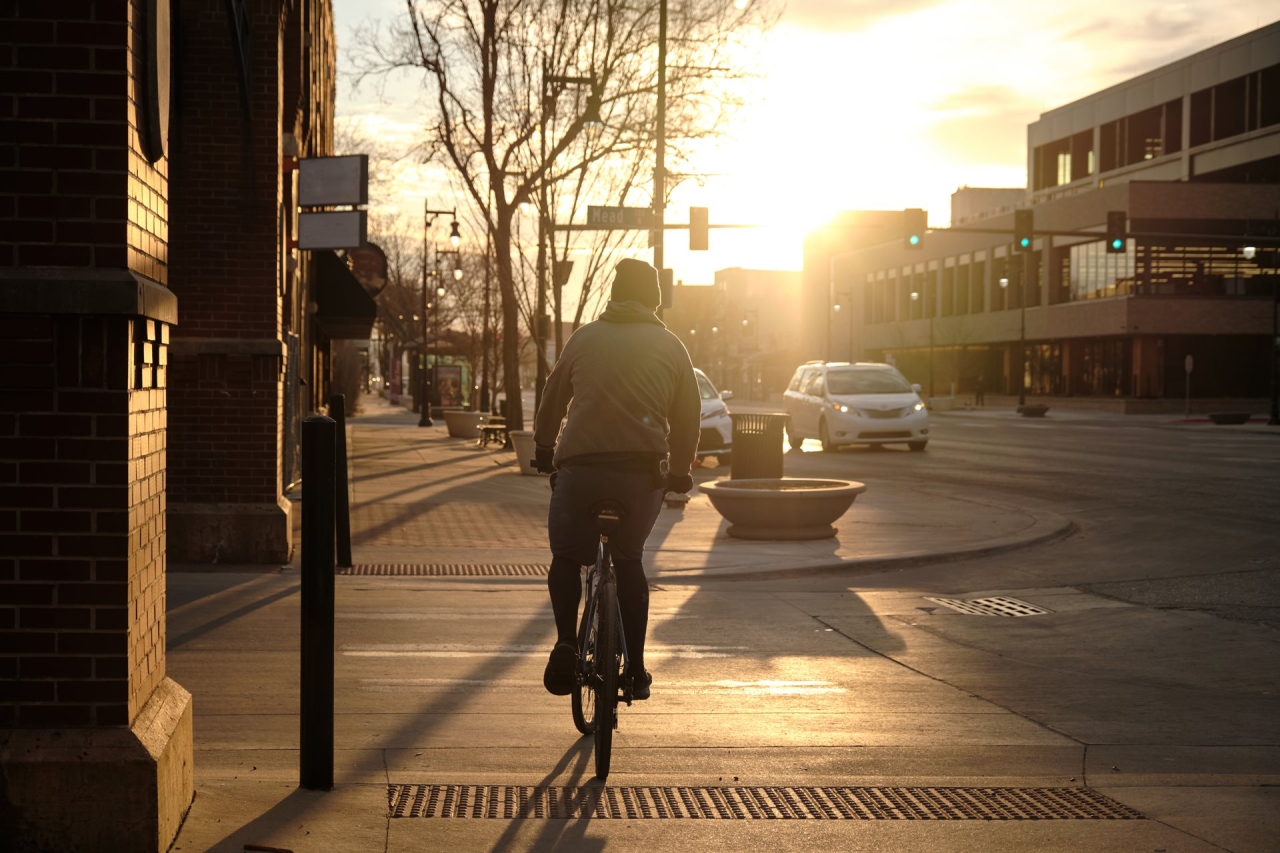 Richard McMichael riding his bike in a city at dawn
