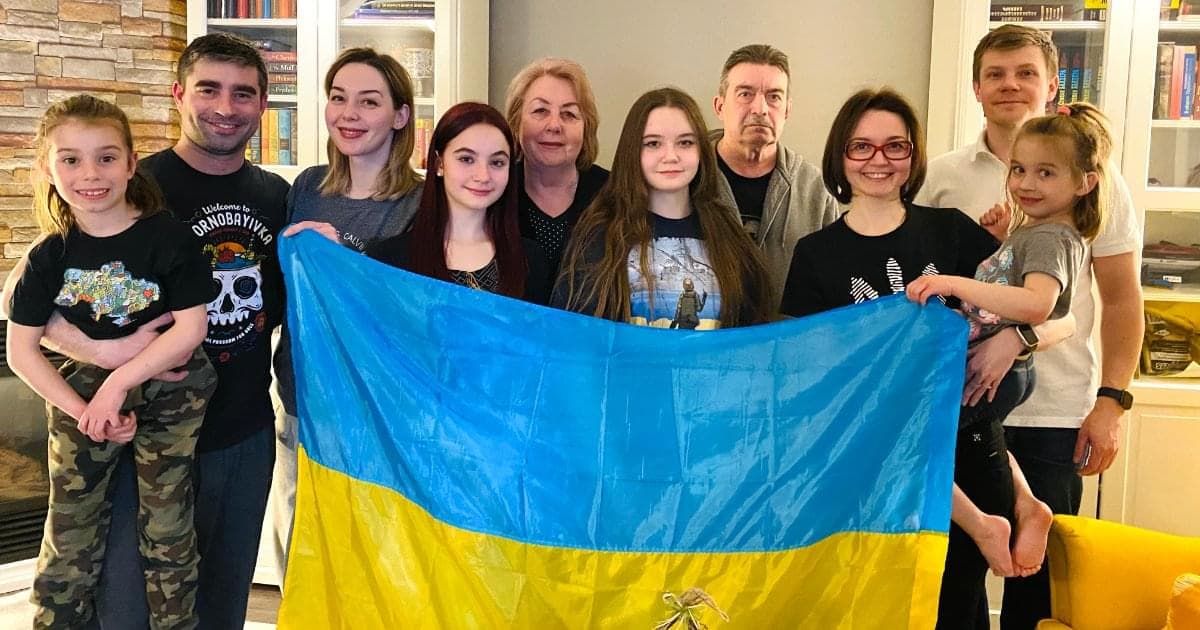 Sergii and family, some holding a Ukraine flag.
