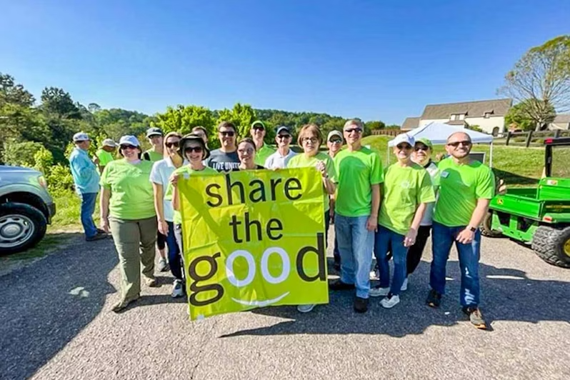 Volunteers with a share the good banner