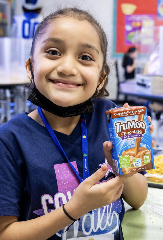 smiling child holding milk