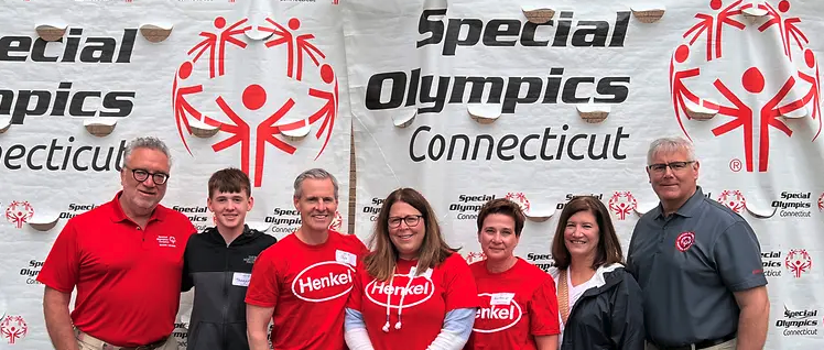 Henkel employees standing before Special Olympics Connecticut banner