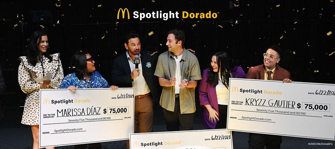 McDonalds logo and "Spotlight Dorado" above three award recipients and presenters holding large checks as confetti falls.