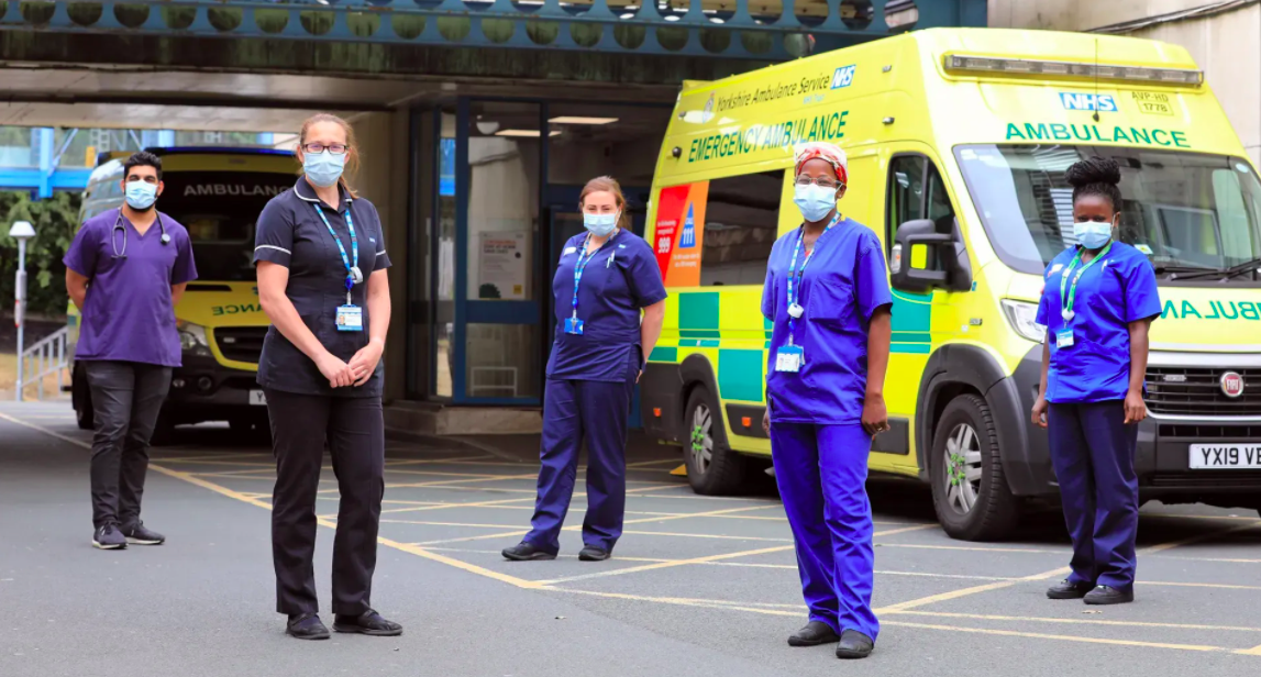 Doctors and Nurses posing near an ambulance