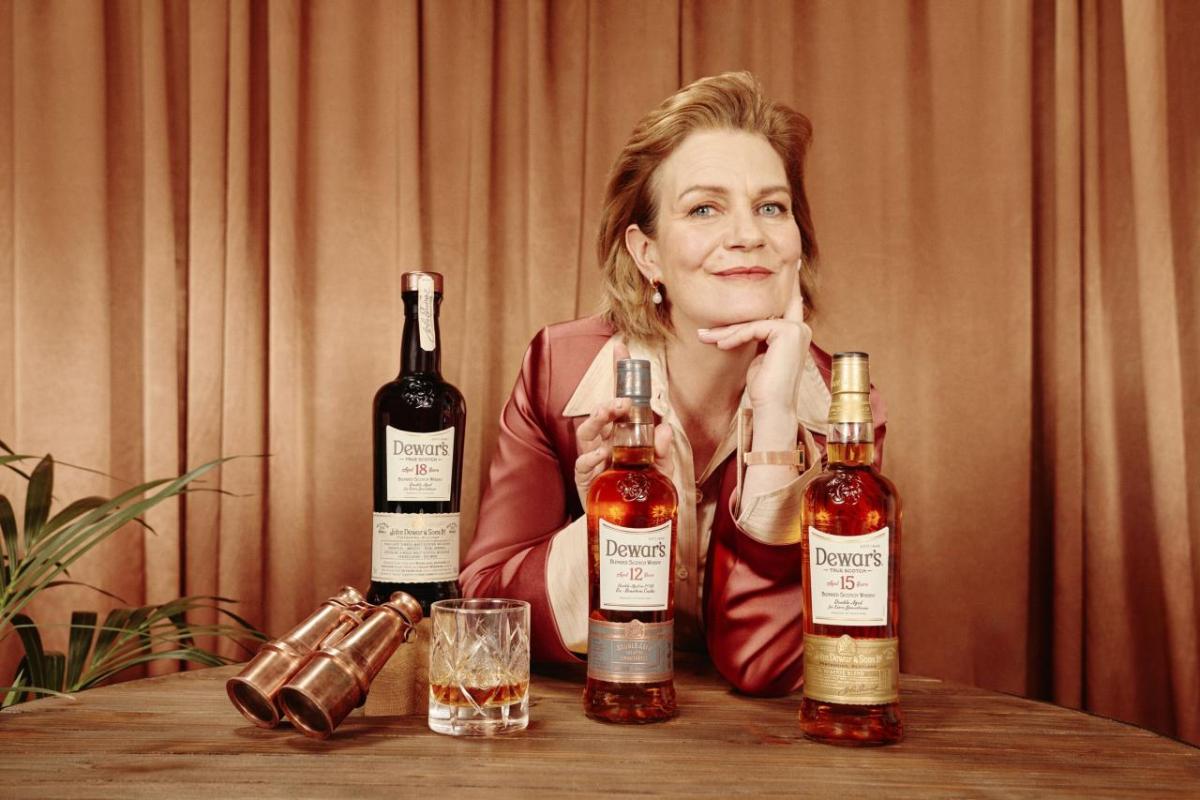 Stephanie Macleod sitting with DEWAR whisky bottles