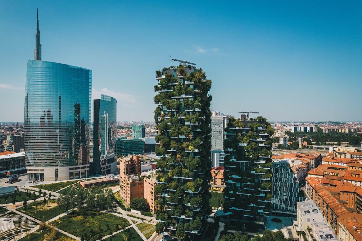 Two buildings shown with greenery.