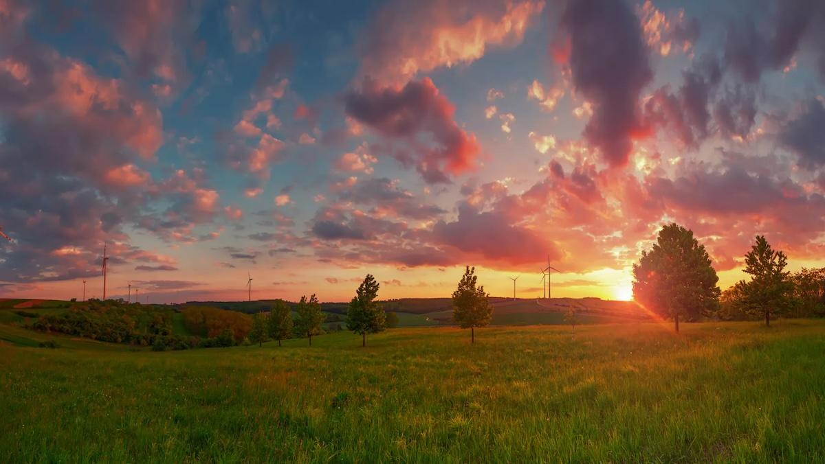 Sunset shown over a beautiful green field.