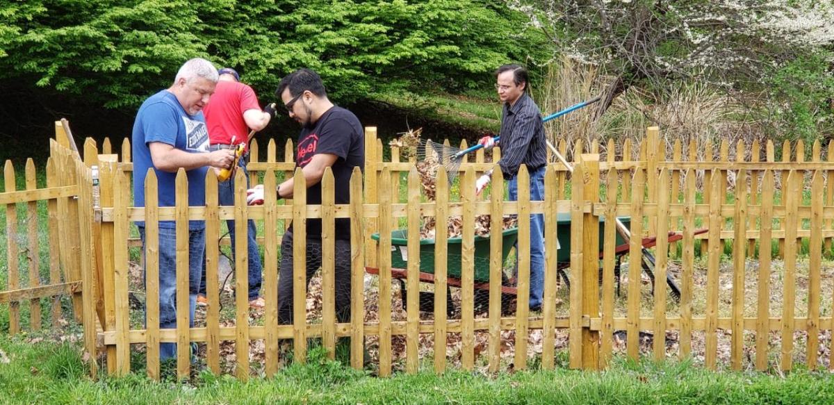 Henkel employees inside an enclosed fenced area with outdoor tools