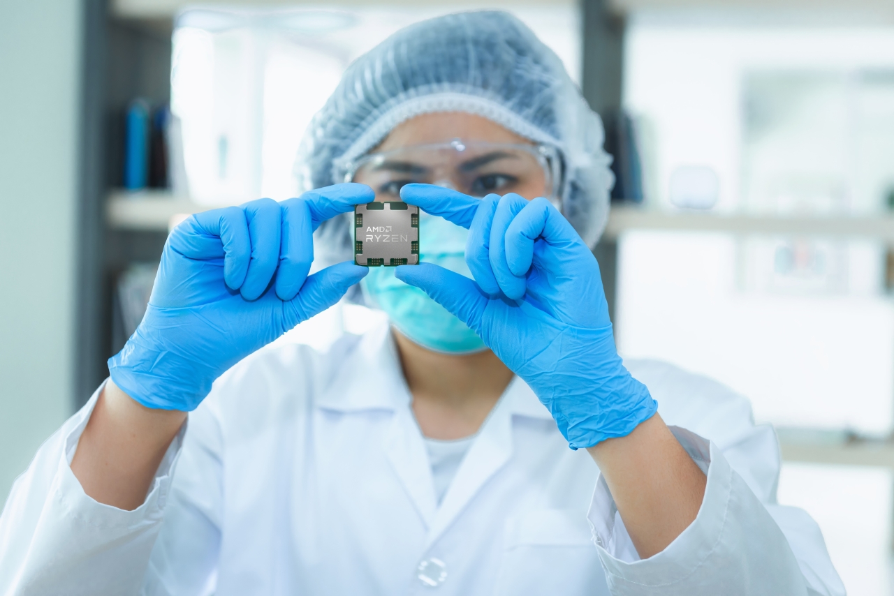 person in full ppe examining a microchip