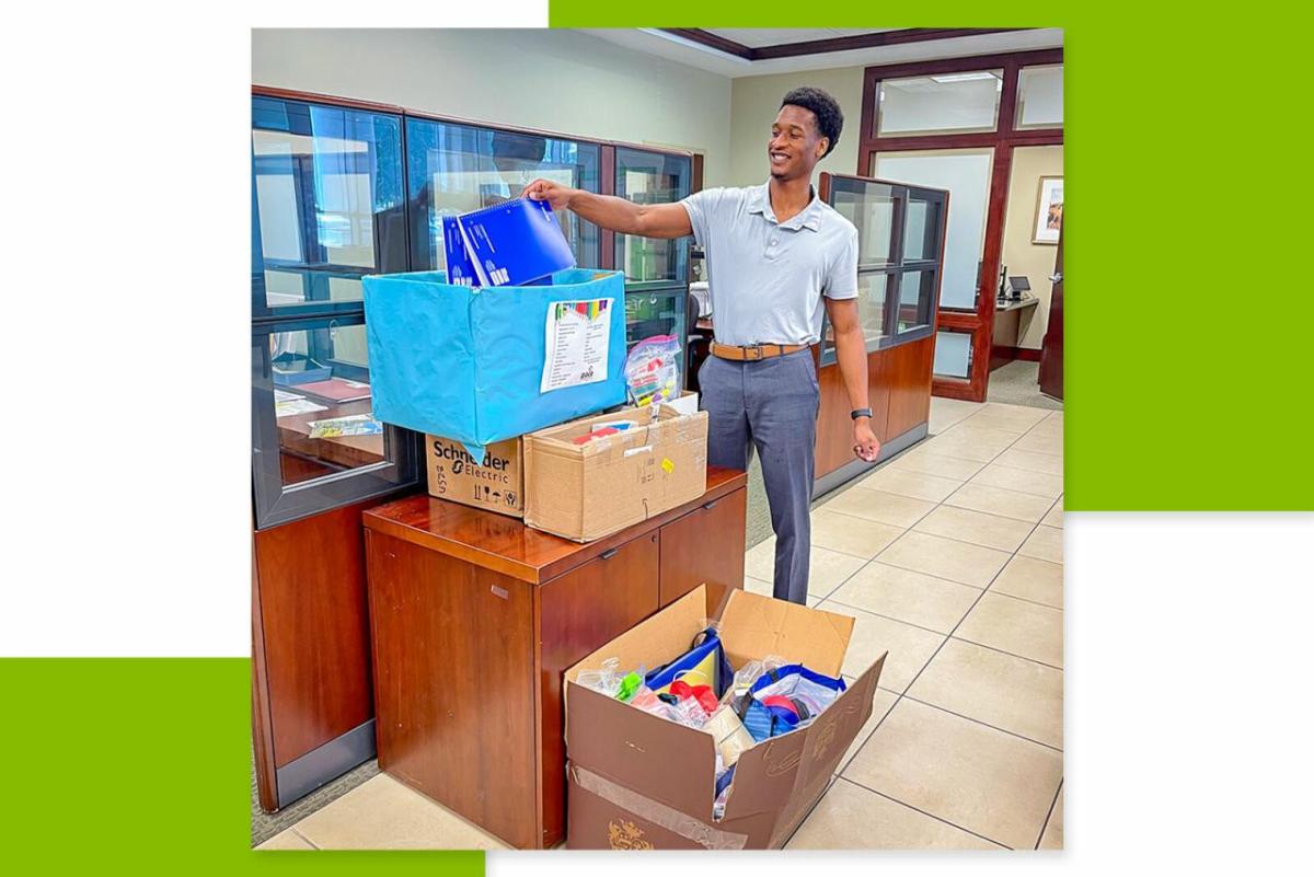 A person putting notebooks into a collection box in side a bank location.