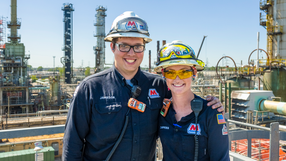 Tara Chippewa with her brother Jamieson Richardson in work and safety gear overlooking the plant in the background.