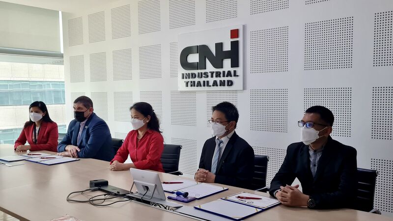 group of people all wearing protective masks sit at a conference table with CNHI sign behind them