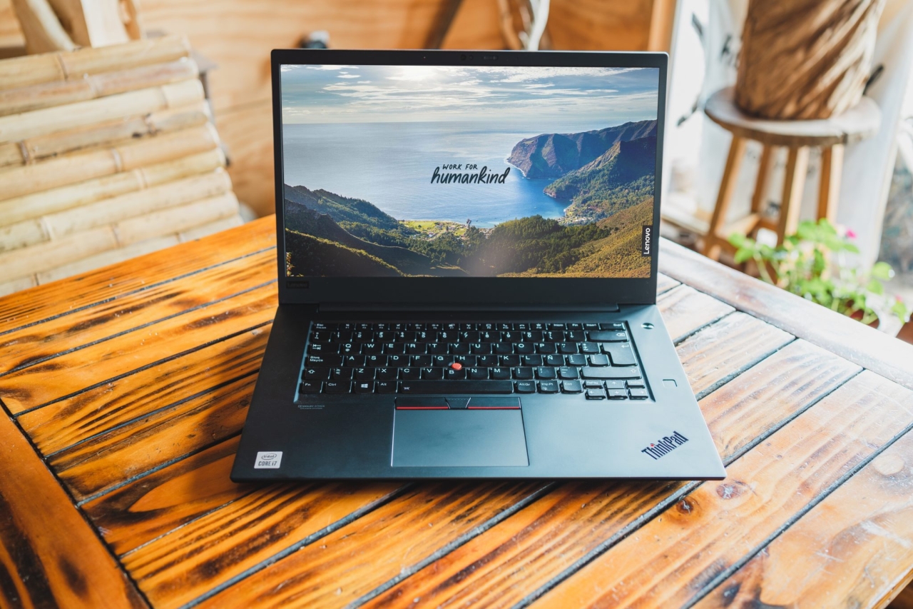 Lenovo ThinkPad on a wood table displaying a Work for Humankind screen saver