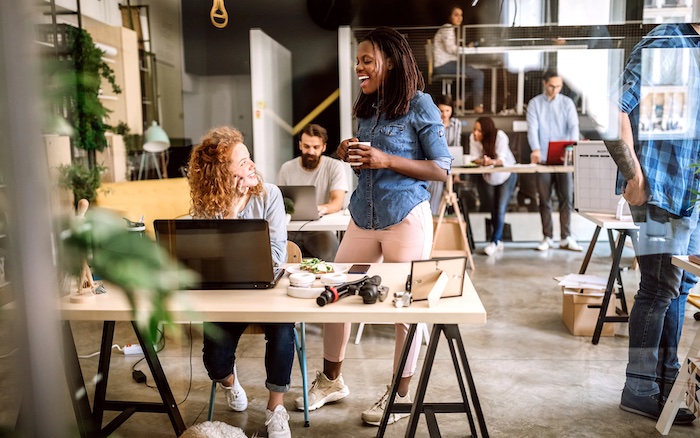 Female employees chatting in an office space.