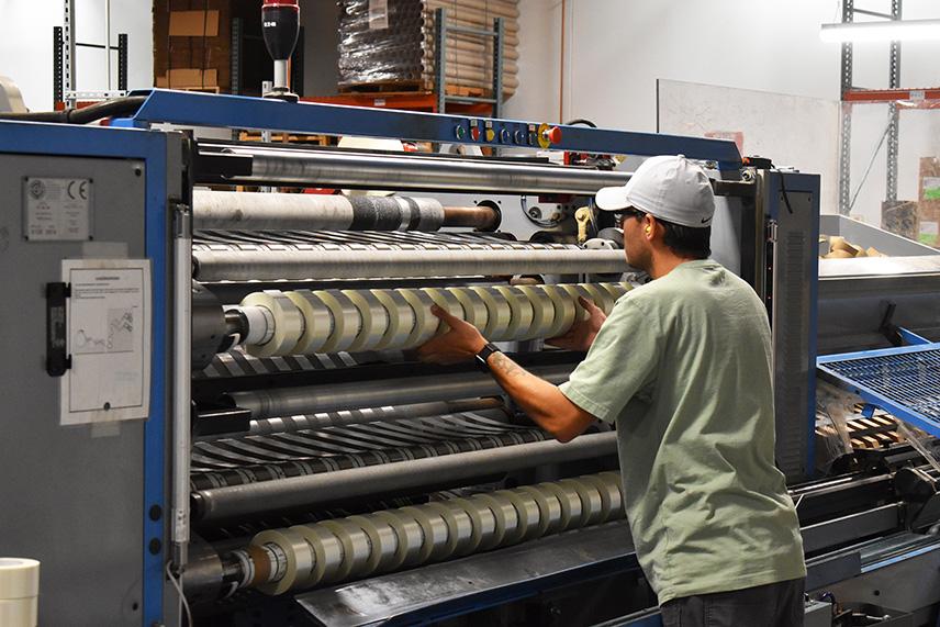 Blind employee at AbilityOne facility shown operating machinery.