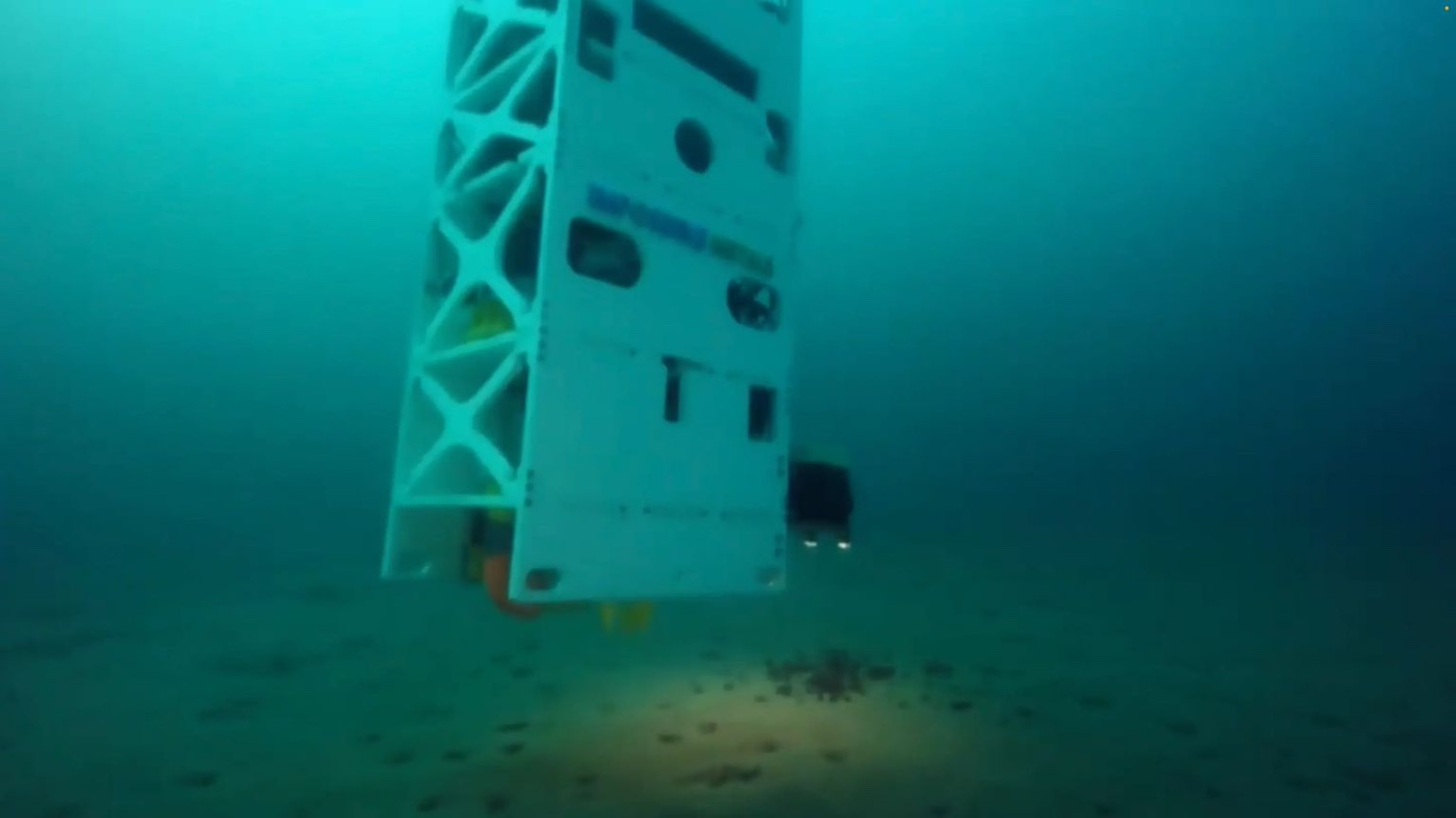 Impossible Metals' autonomous deep-sea mining vehicle hovers over the seabed during an underwater test.