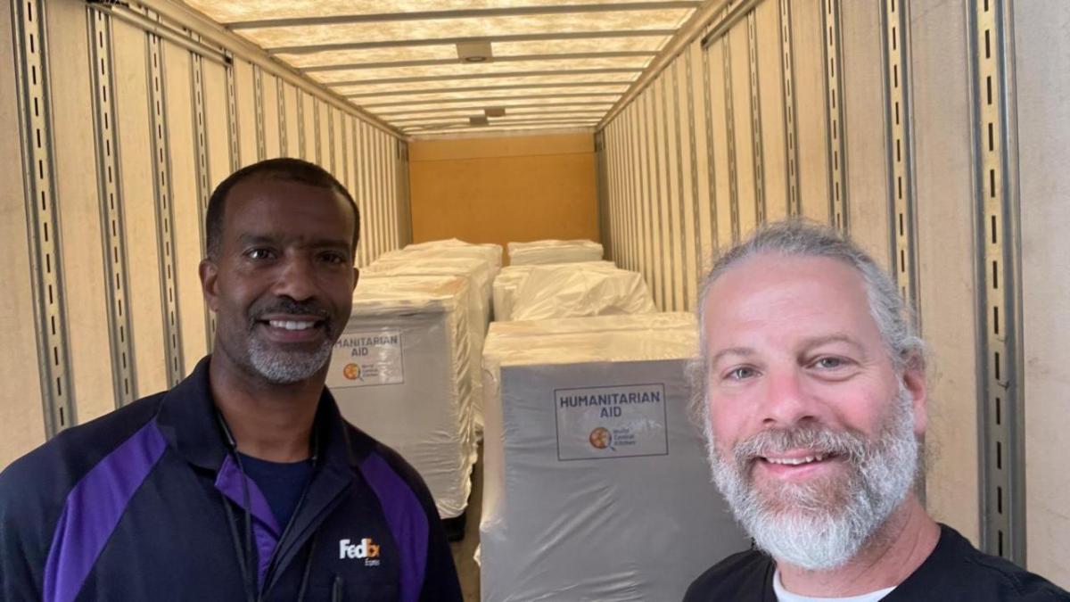 two people smiling with packages in background