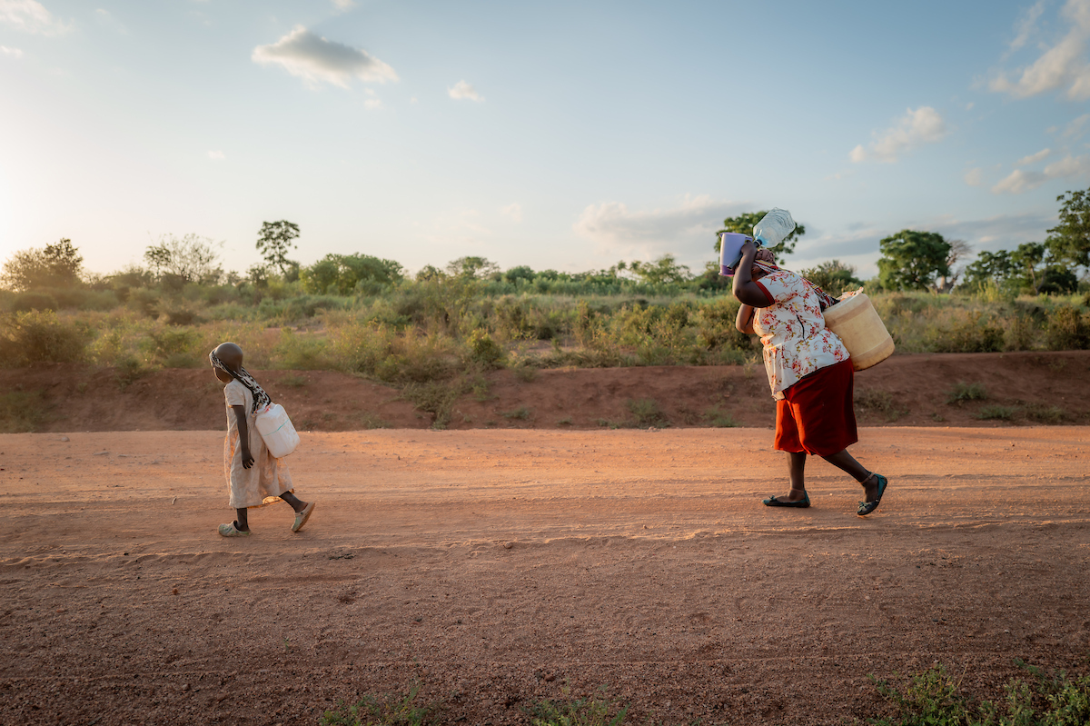 Celestine and her grandmother carrying water
