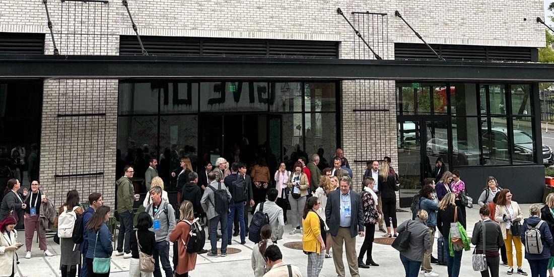 A group of scattered people outside a building