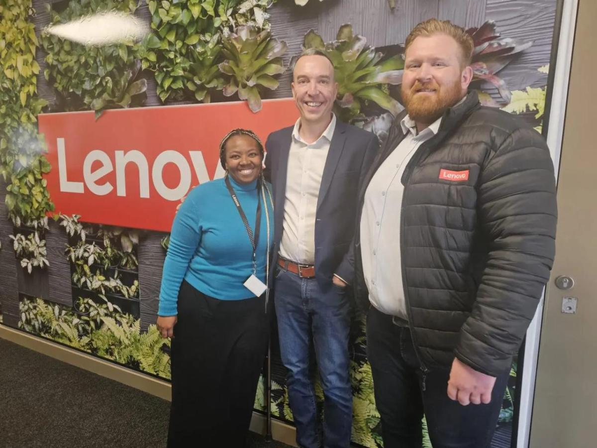 Werner Schoeman and team members in front of a Lenovo sign.