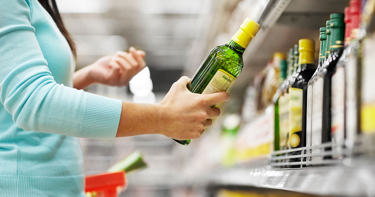 Person picking out bottle off store shelf
