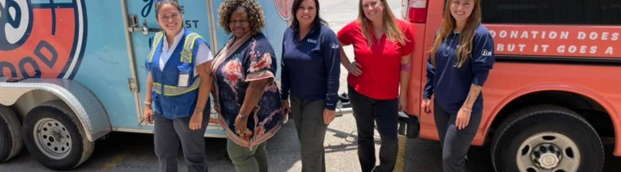 women in front of trucks