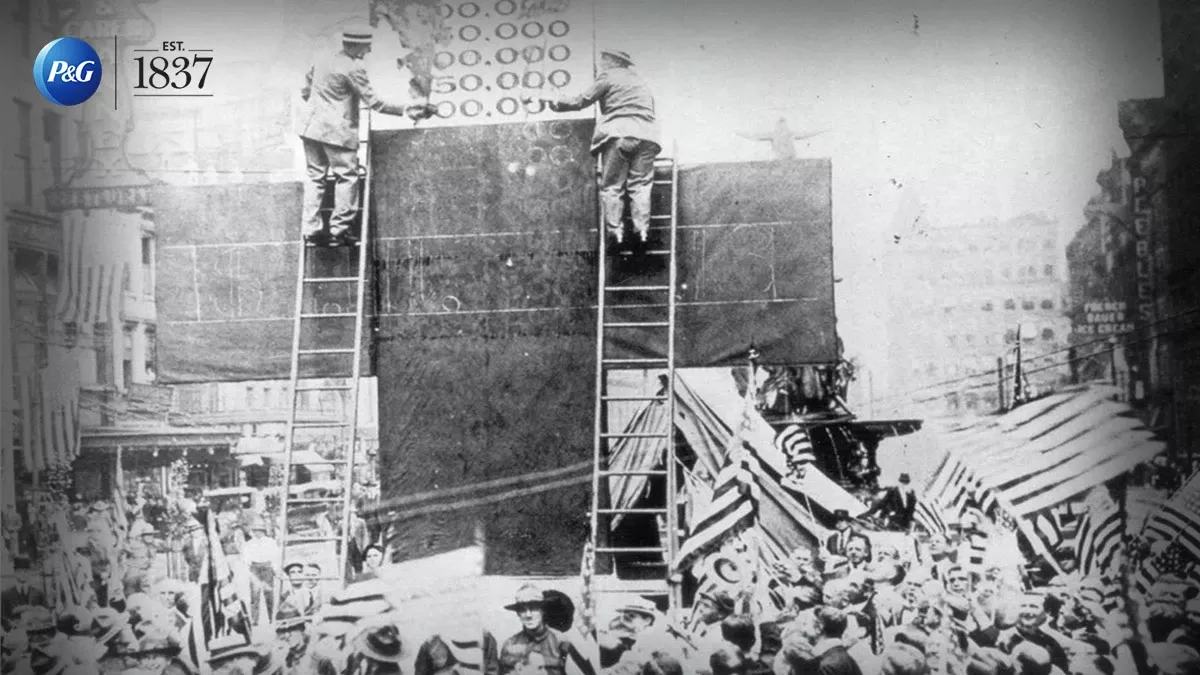 Two people on a ladder painting a cross 